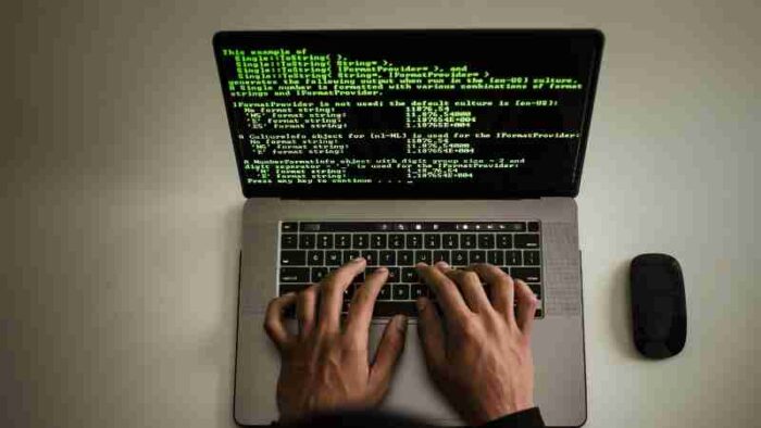 From above crop anonymous male programmer in black hoodie working on software code on contemporary netbook and typing on keyboard in workspace, tags: 100-tage-plan - pexel